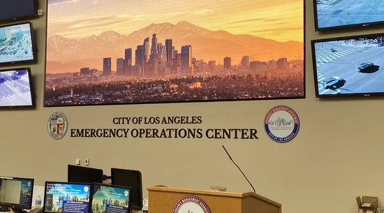 An interior image of the front of the LA City Emergency Operations Center showing the various view screens and operational pods.