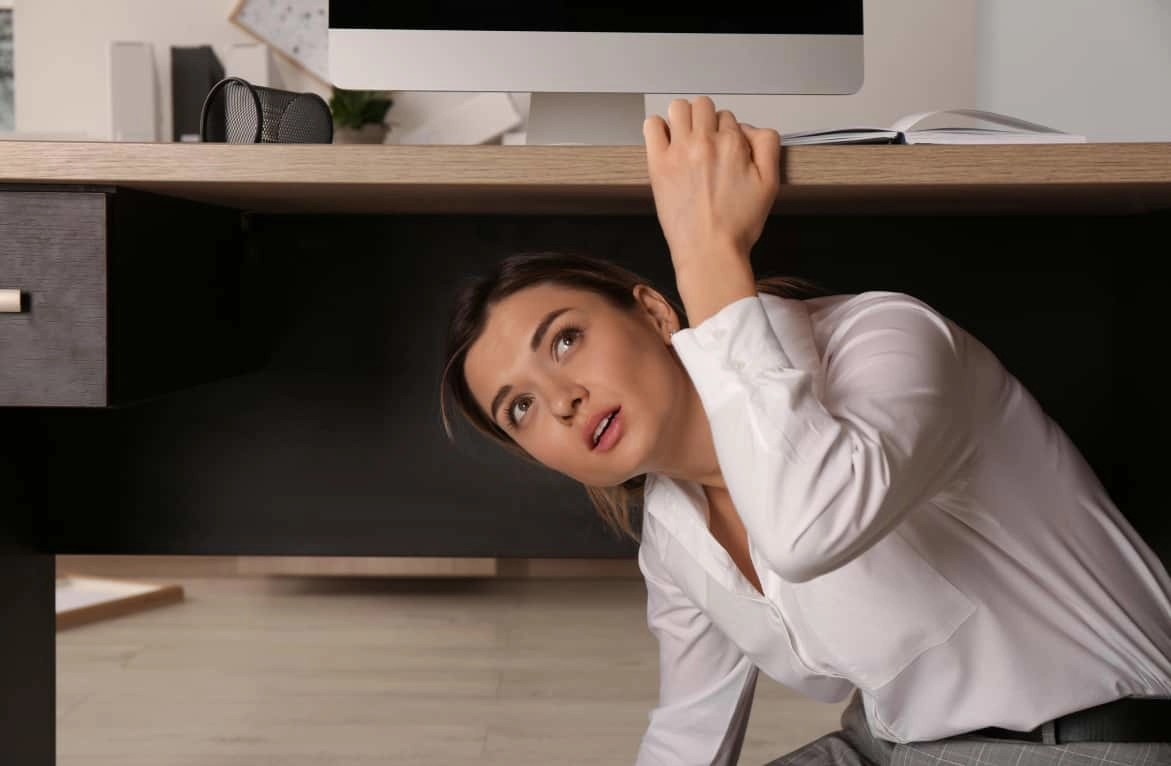 woman-sheltering-under-desk