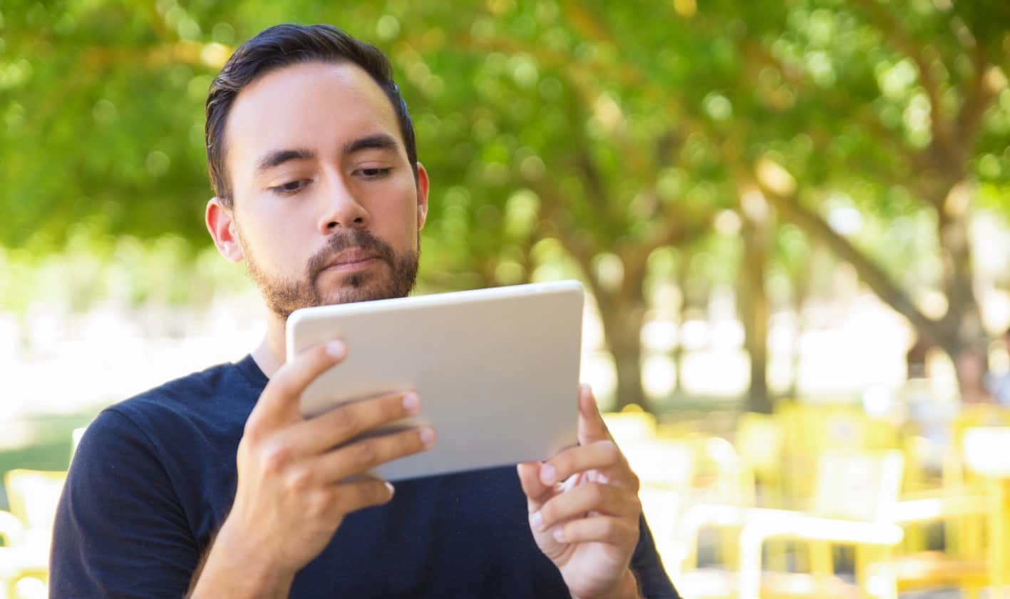 young-man-using-tablet-pc-outdoor-bearded-young-man-holding-digital-tablet-while-standing